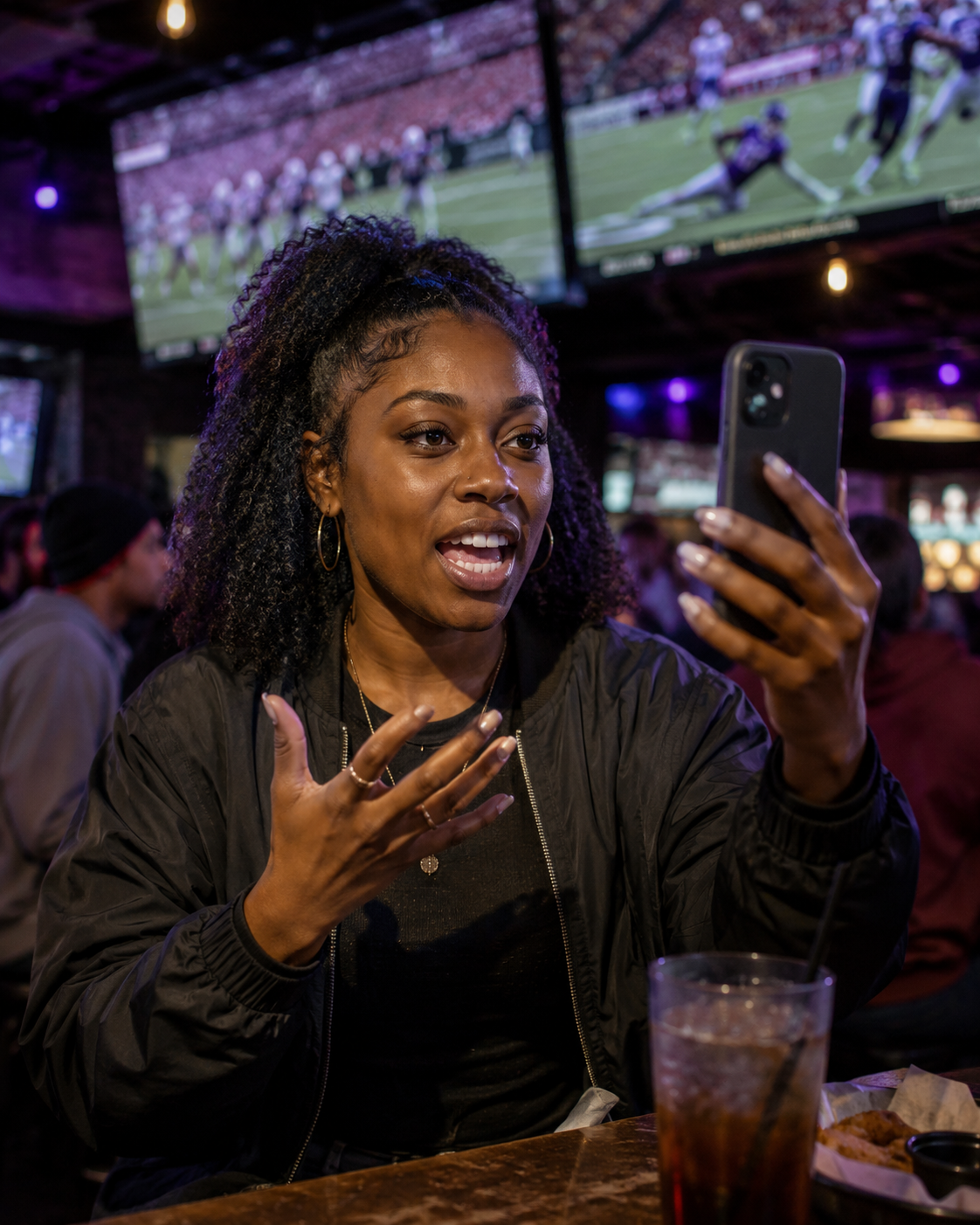 Woman recording a sports take on her phone at a sports bar